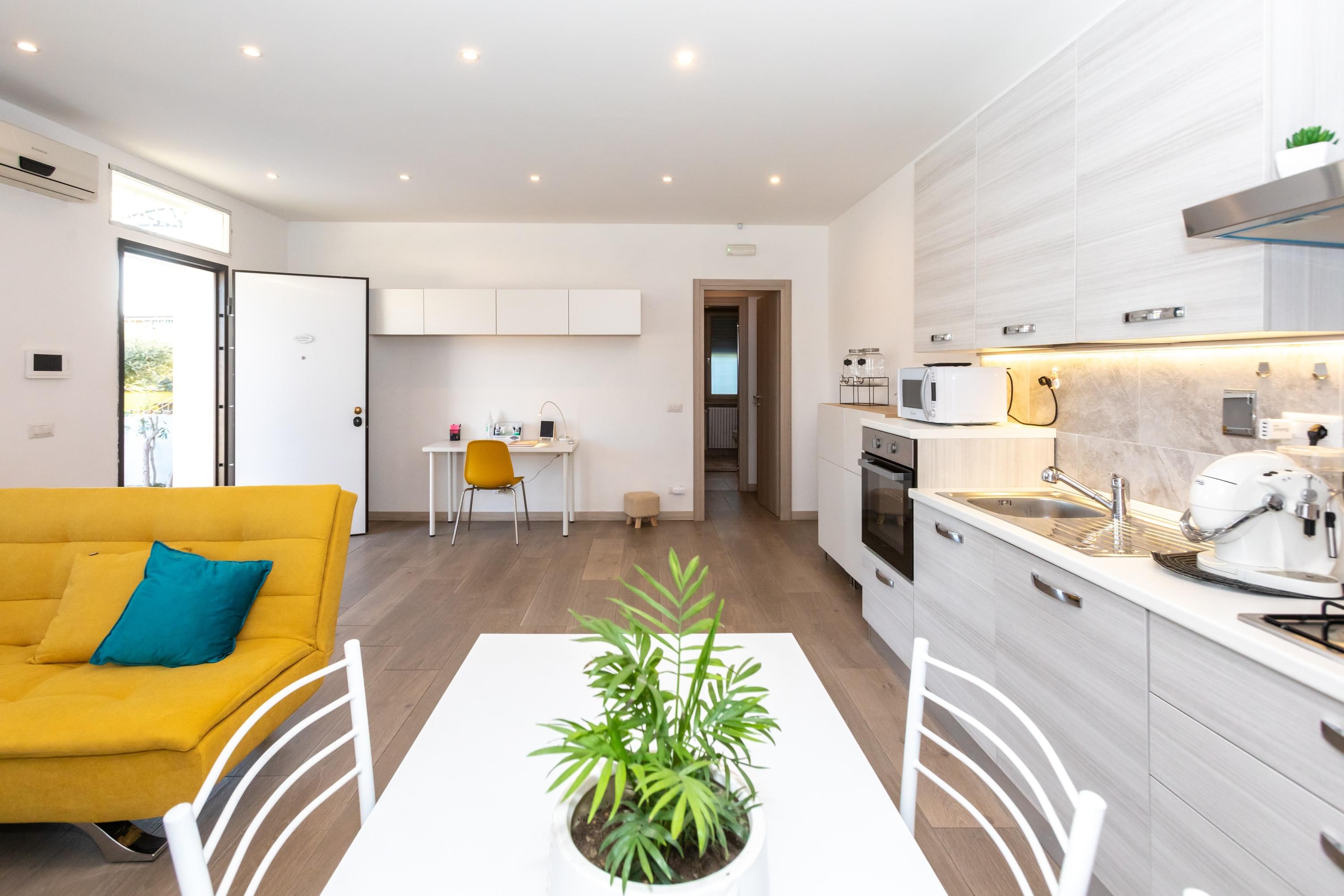 salone moderno con cucina, divano e scrivania